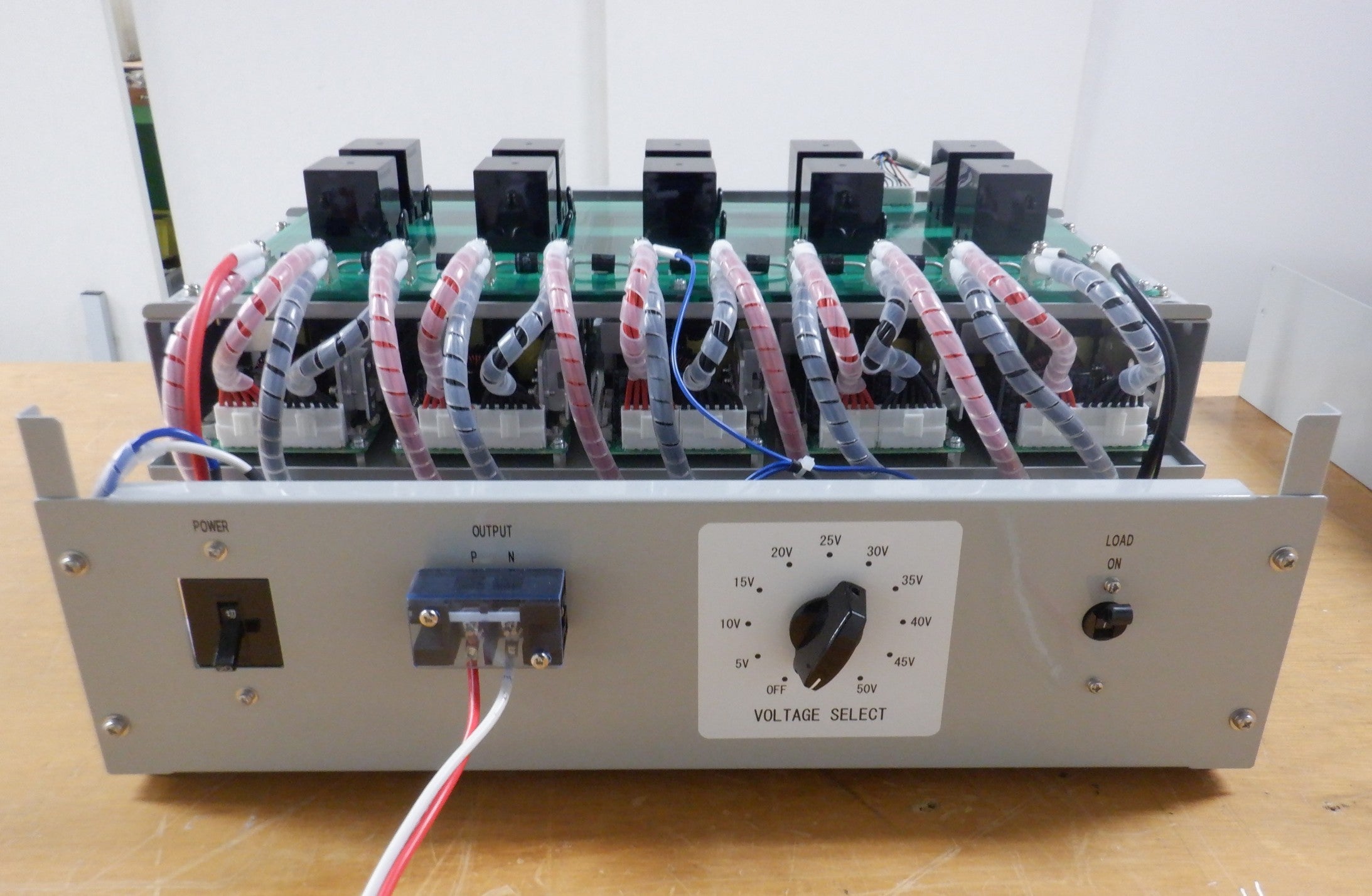 開発されたDCモータ速度コントローラの試作品写真。筐体の上部に複数の回路基板や配線が見え、前面パネルにはスイッチや調整つまみが配置されている。